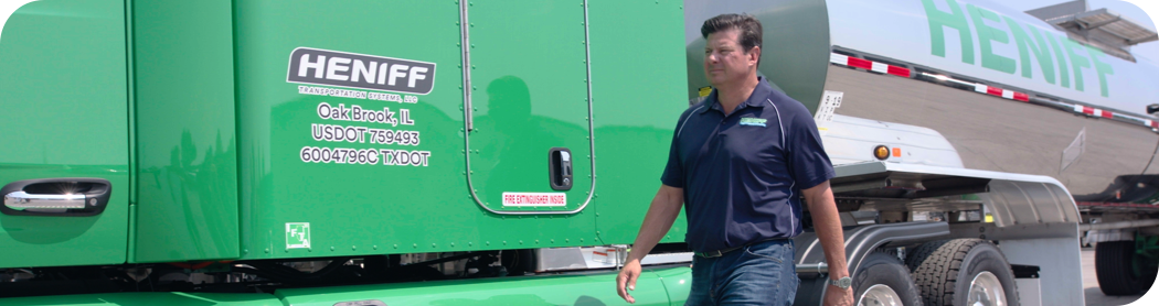 Man walking past a green semi-truck